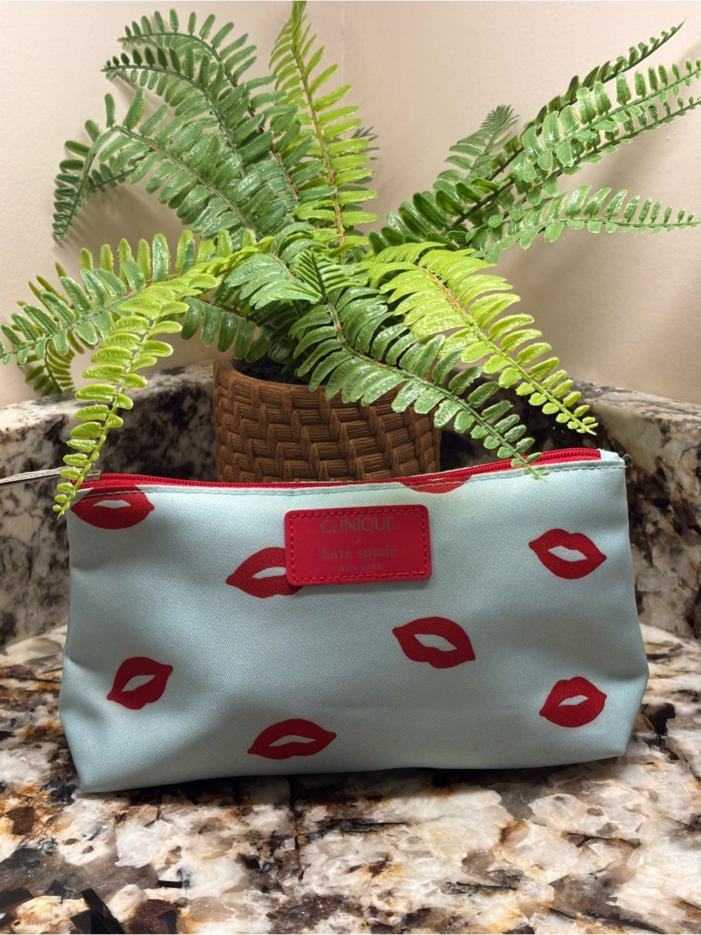 kate spade light blue cosmetic pouch with red lip print